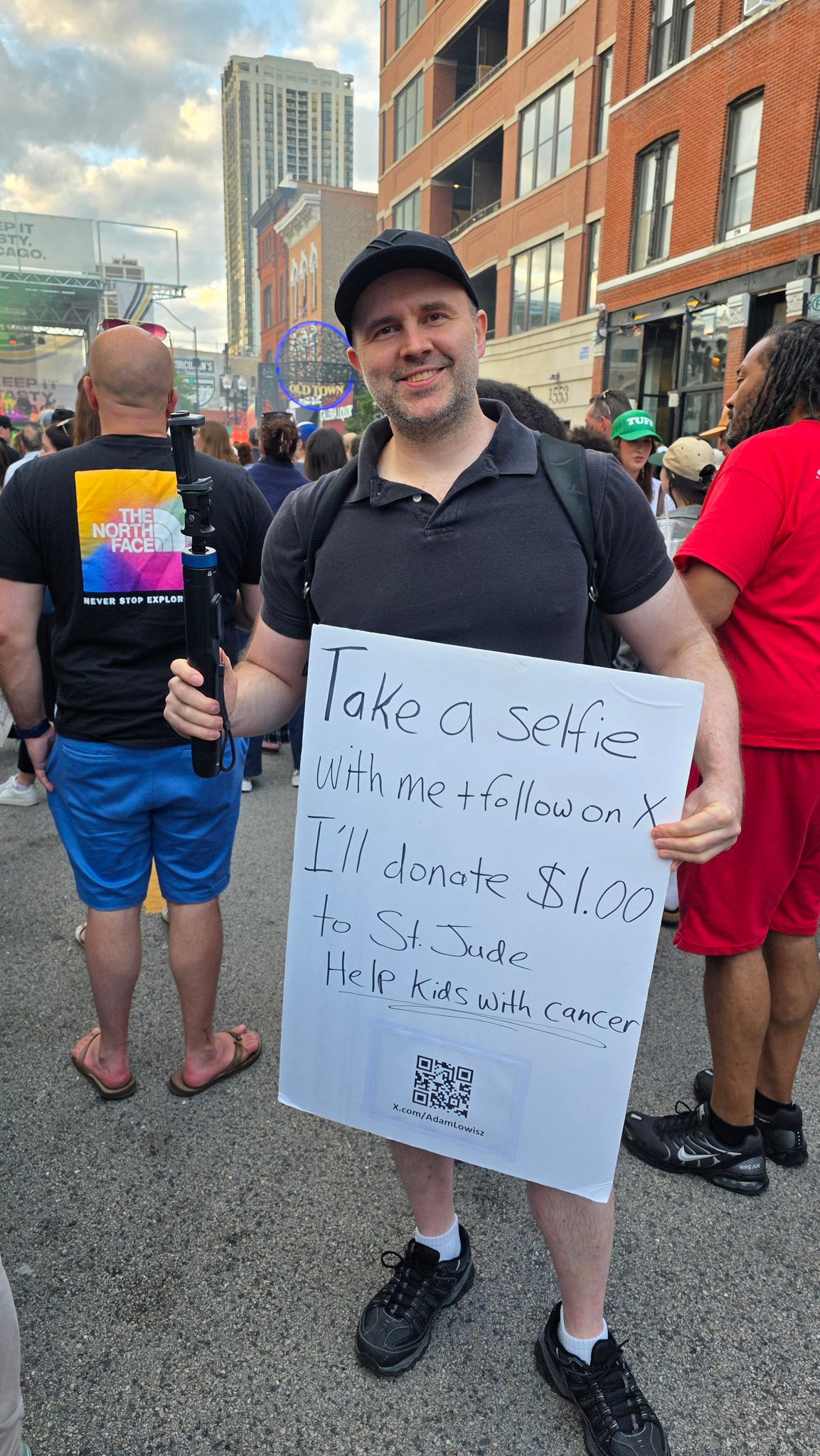 Adam at the Wells Street Art Festival holding a Take a Selfie with me sign