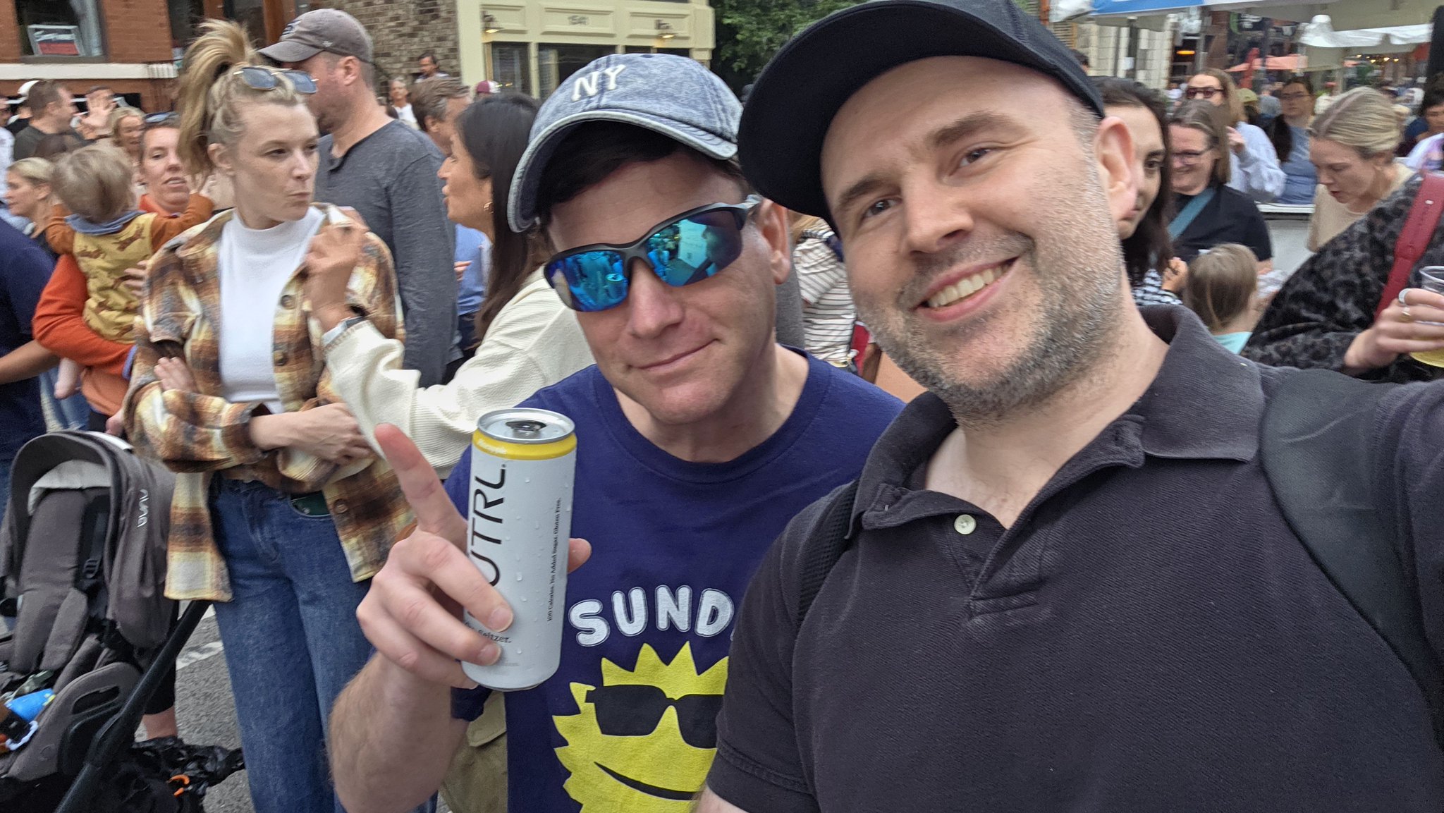 Adam taking a selfie with a festival-goer in a white tank top at Wells Street