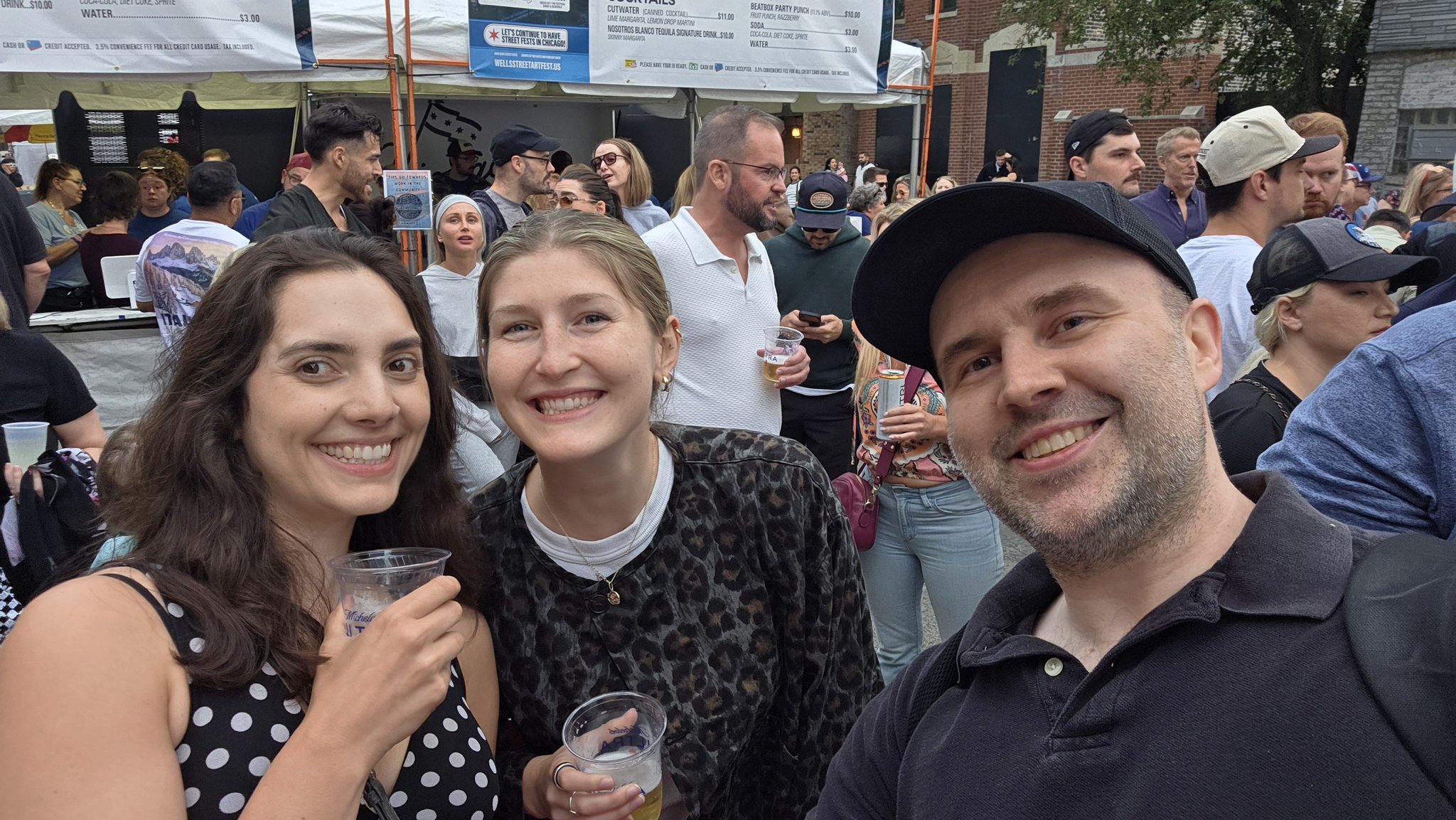Adam taking a selfie with a festival-goer wearing sunglasses at Wells Street