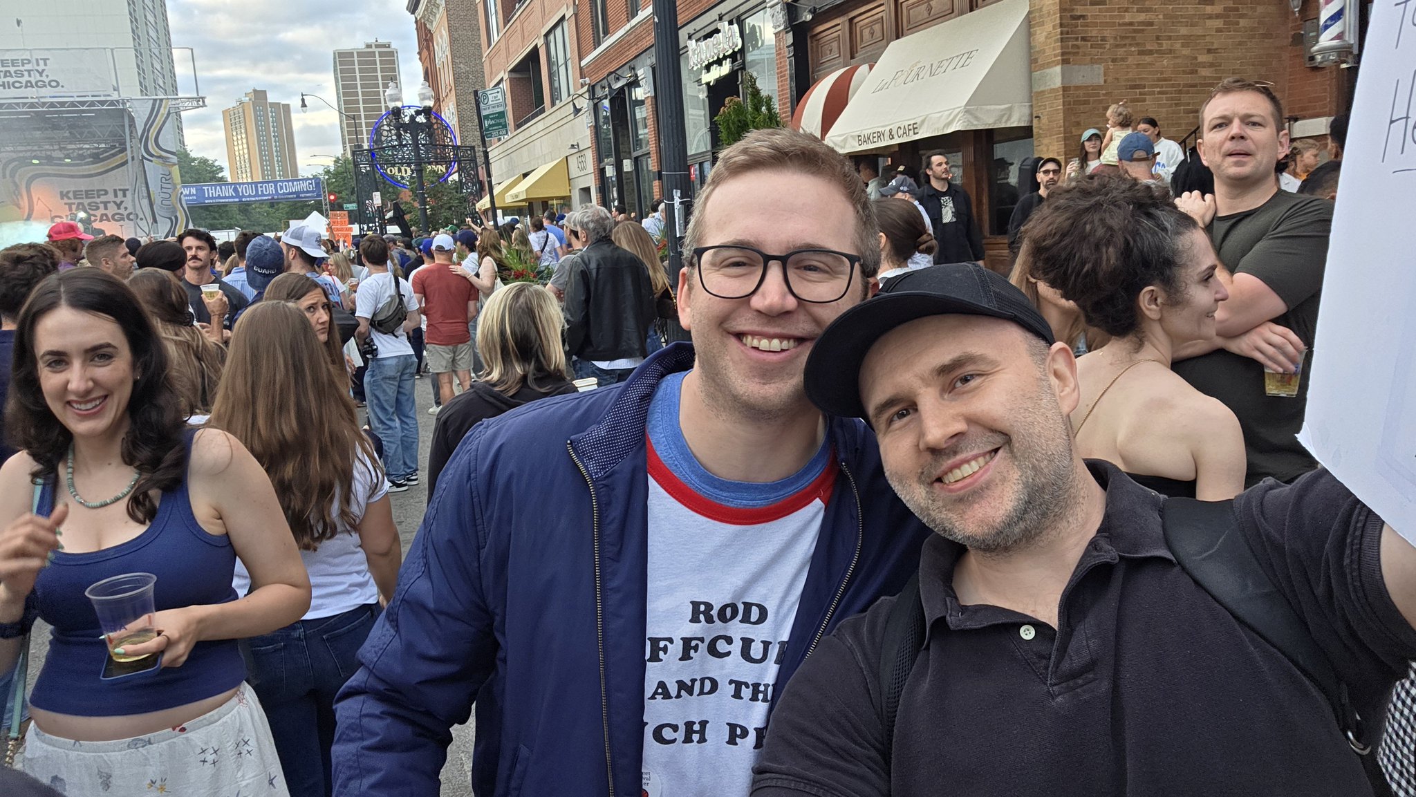 Adam taking a selfie with a festival-goer in a gray tank top at Wells Street